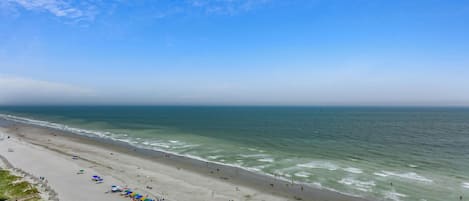 A beach with umbrellas and people.