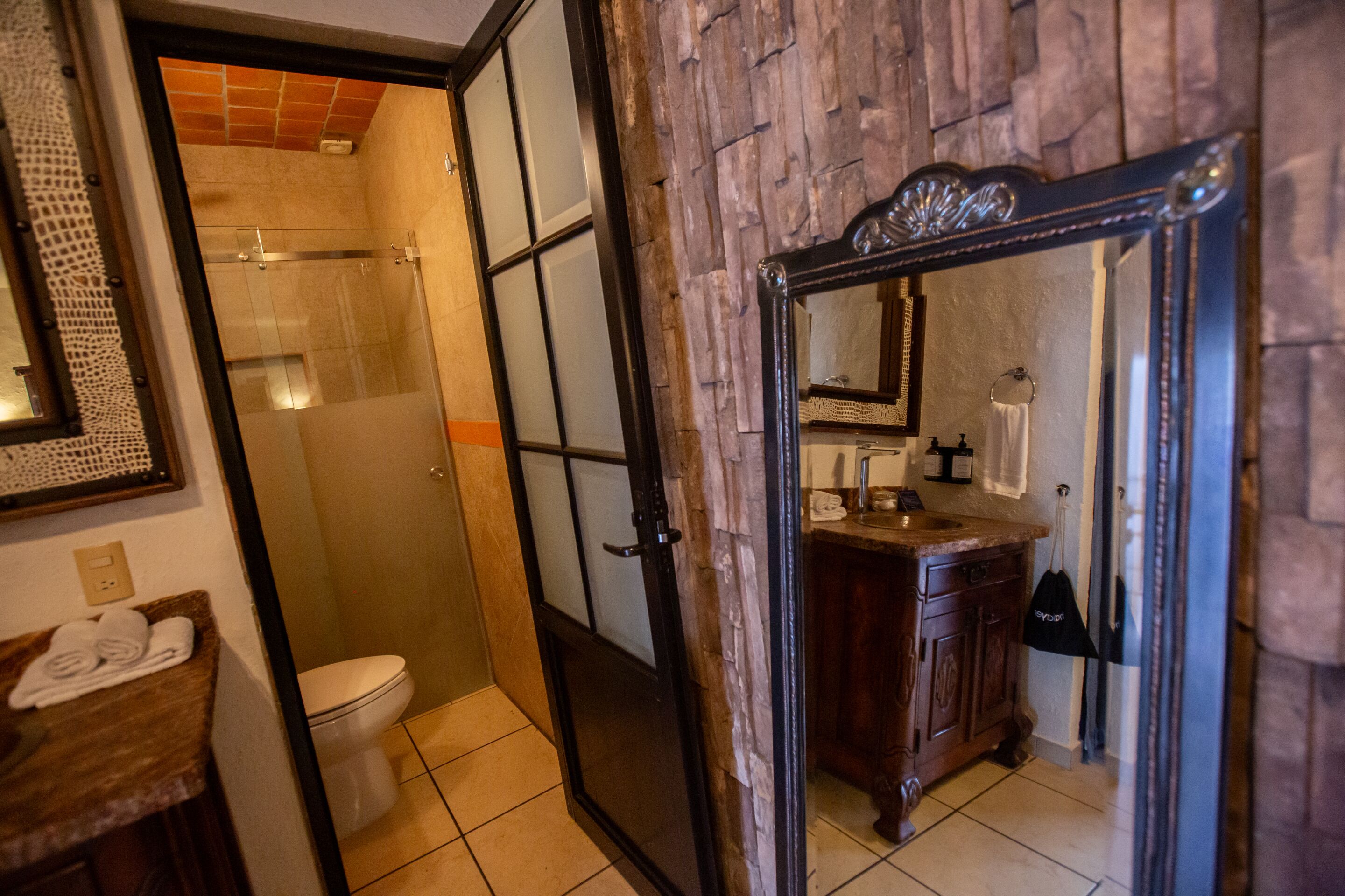 Un baño con ducha, inodoro y tocador.