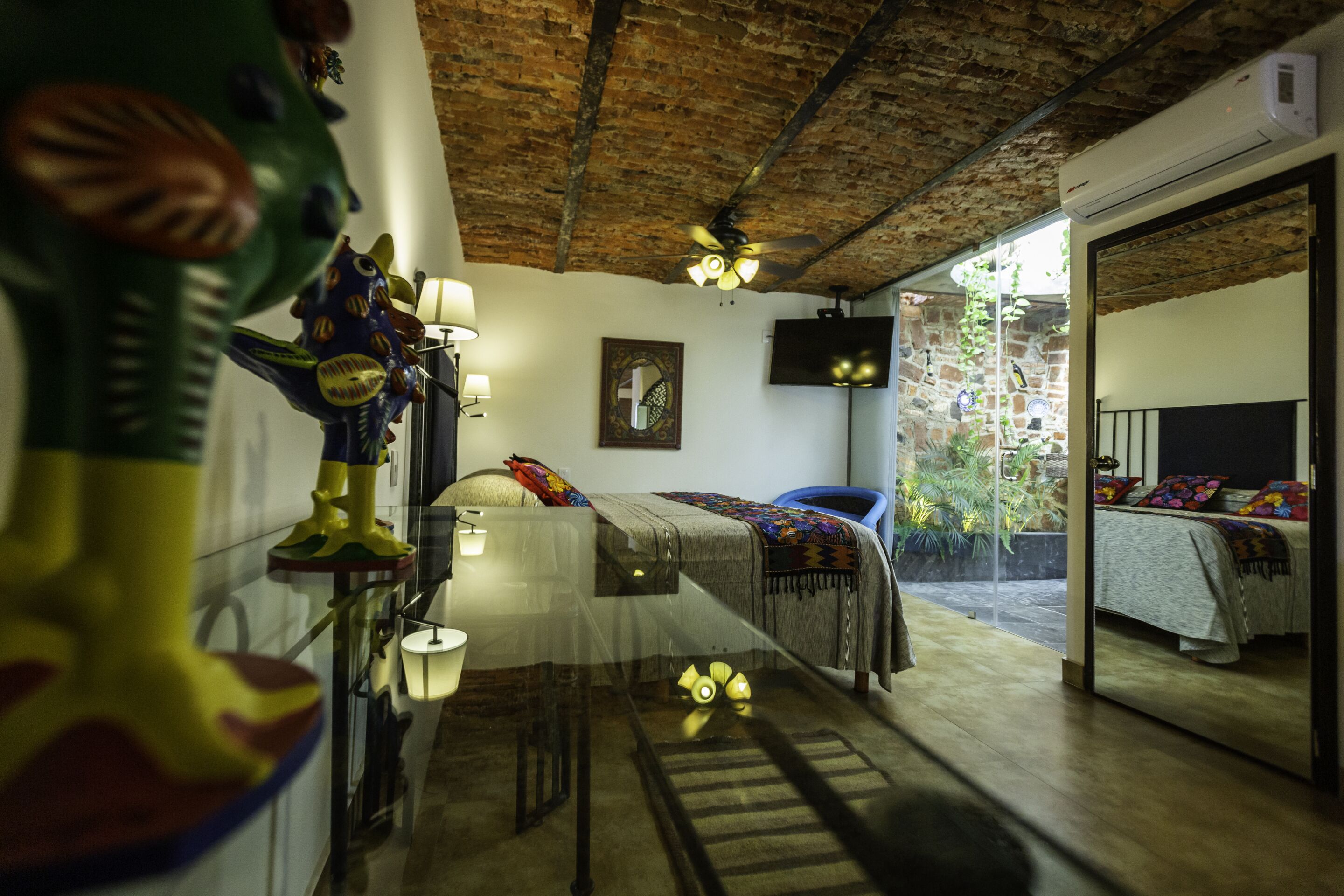 A room with a bed, a chair, a table, and a decorative figure.