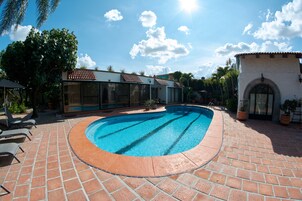 Una piscina al aire libre, sillones reclinables de piscina
