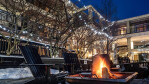A snow-covered outdoor area with a fire pit and two Adirondack chairs. - Hockley Valley Resort (Mono)