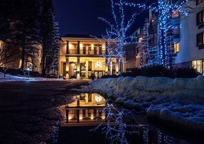 A building with a reflective pool in front, surrounded by snow and illuminated by blue lights. - Hockley Valley Resort (Mono)