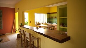 A kitchen with a wooden countertop, chairs, and a window. - Hostal San Pancho - Hostel (San Francisco)