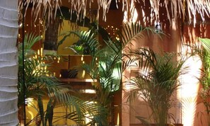 Una habitación con temática tropical, con plantas de palma y una pared de madera.