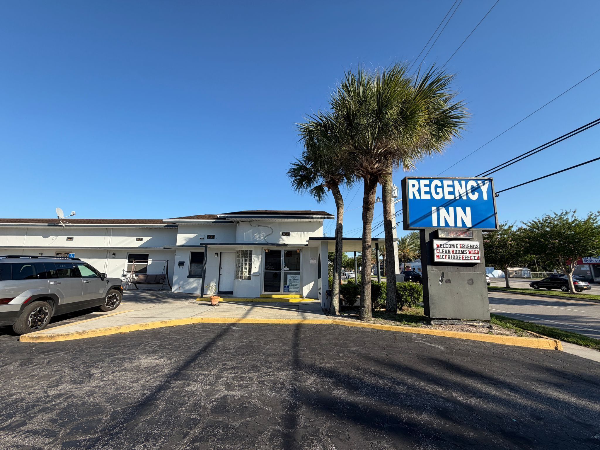 A building with a sign reading 'REGENCY INN' and a welcome sign.