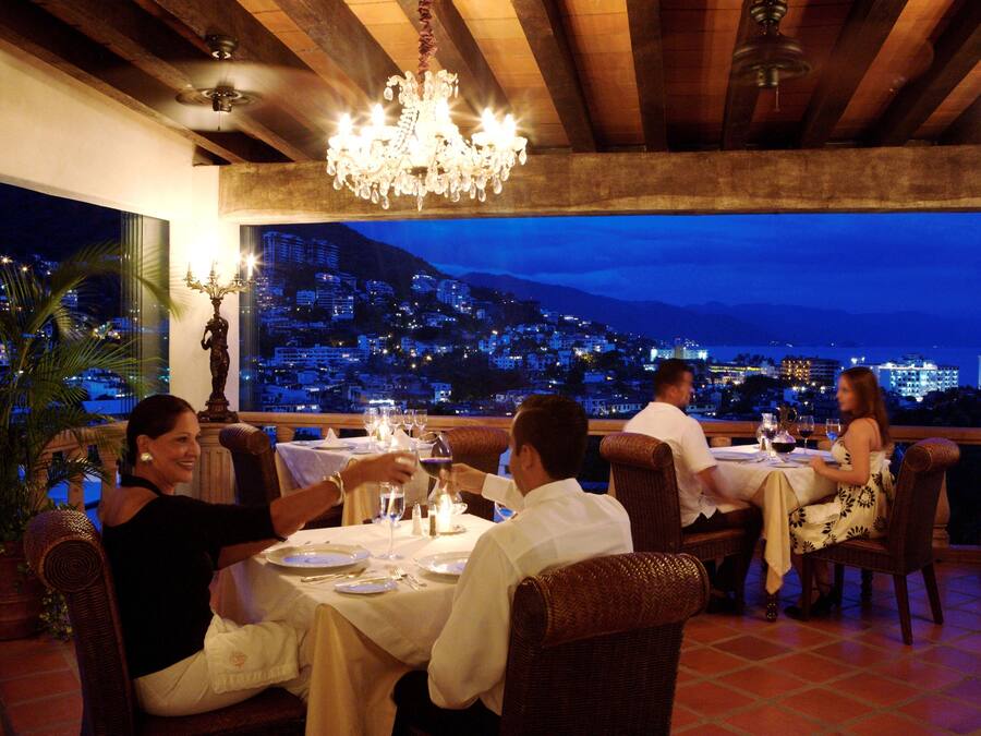 A restaurant with a view of a cityscape at dusk.