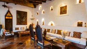 Een klassiek interieur met een stenen vloer, houten meubels en religieuze kunstwerken.