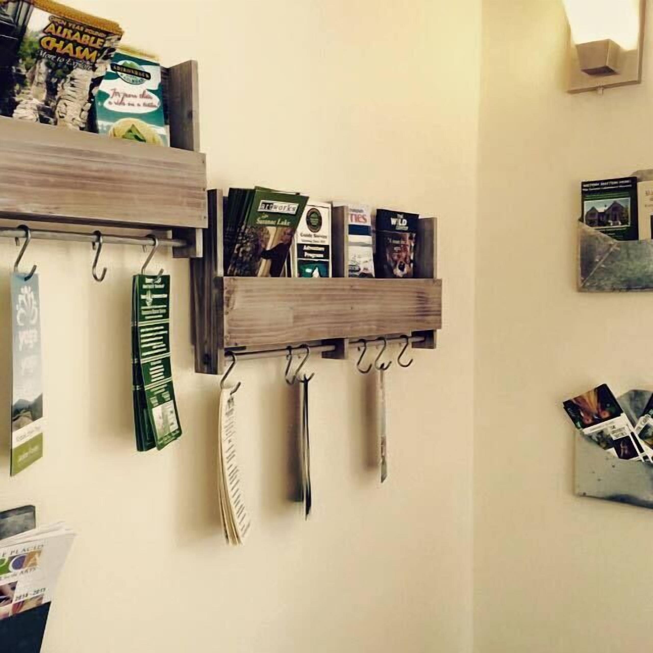 Un mur avec trois étagères en bois sur lesquelles sont disposés divers objets.