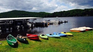 A lakeside dock with several boats and a covered pier.