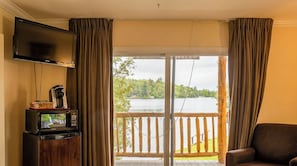 A room with a television, a coffee maker, and a view of a lake. - Gauthier's Saranac Lake Inn (Saranac Lake)