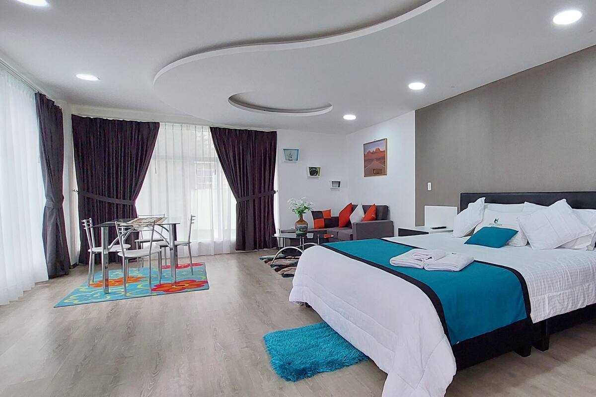 Una habitación de hotel moderna con una cama grande, un escritorio y una silla.