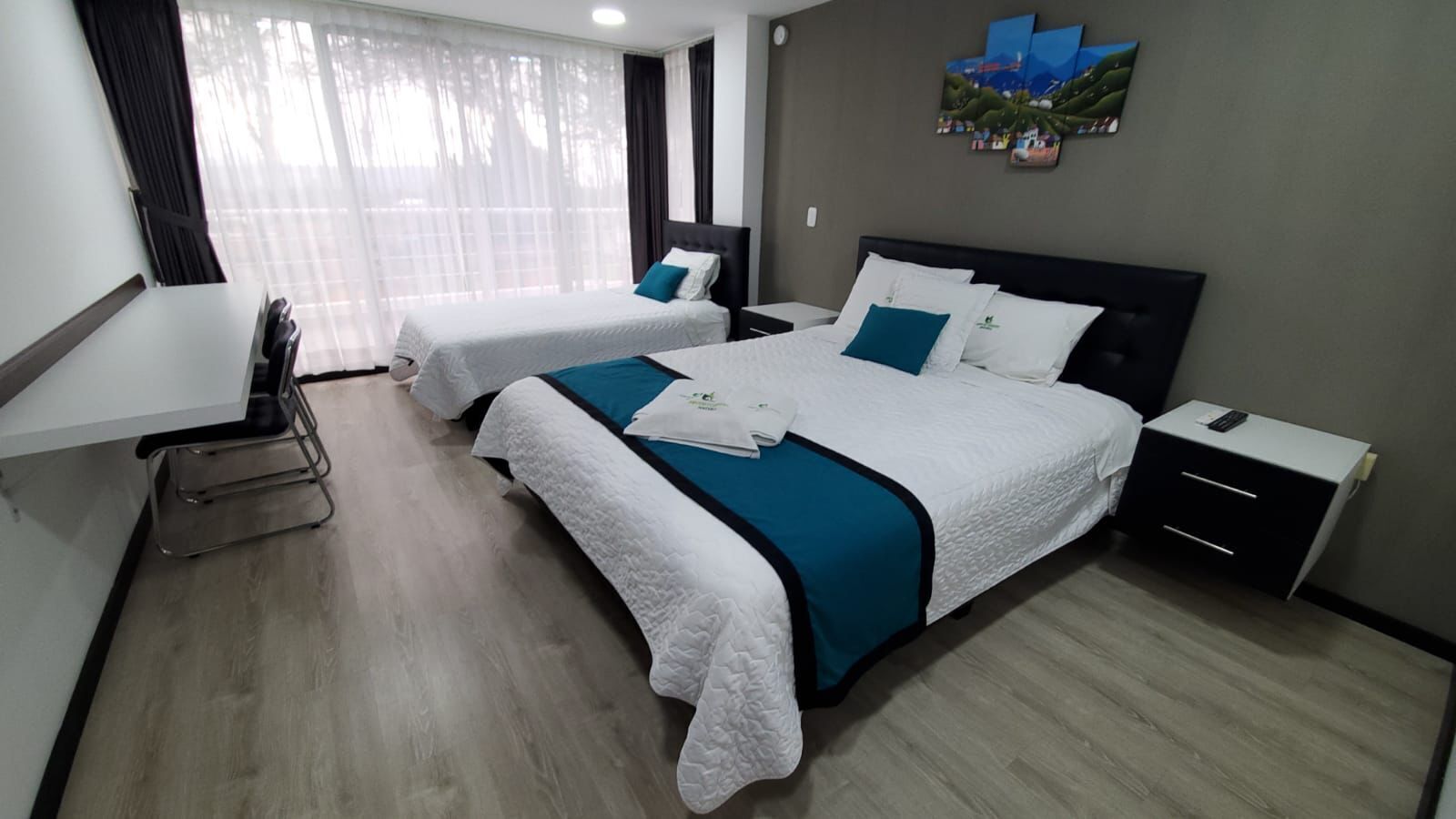 Habitación de hotel con dos camas, un escritorio y una silla.