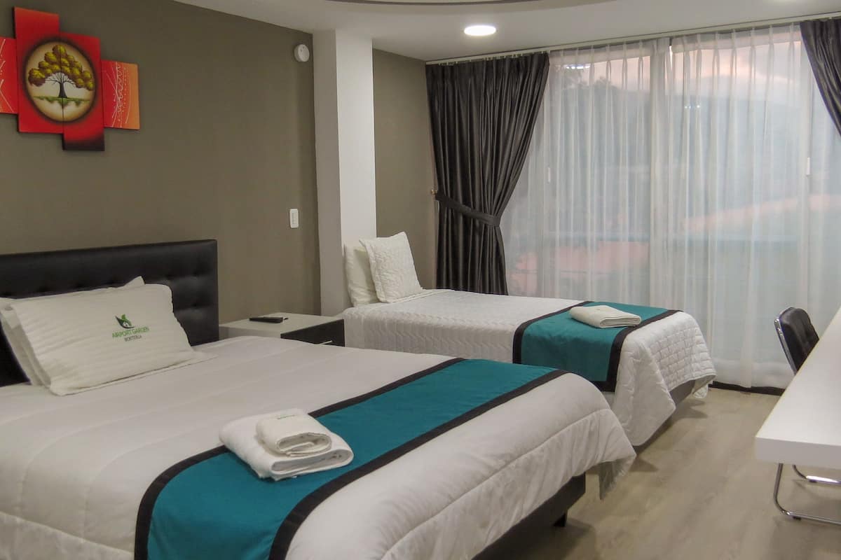 Una habitación de hotel con dos camas, un escritorio y una silla.