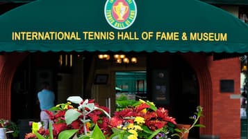 The entrance to the International Tennis Hall of Fame & Museum with a green arch and a sign.