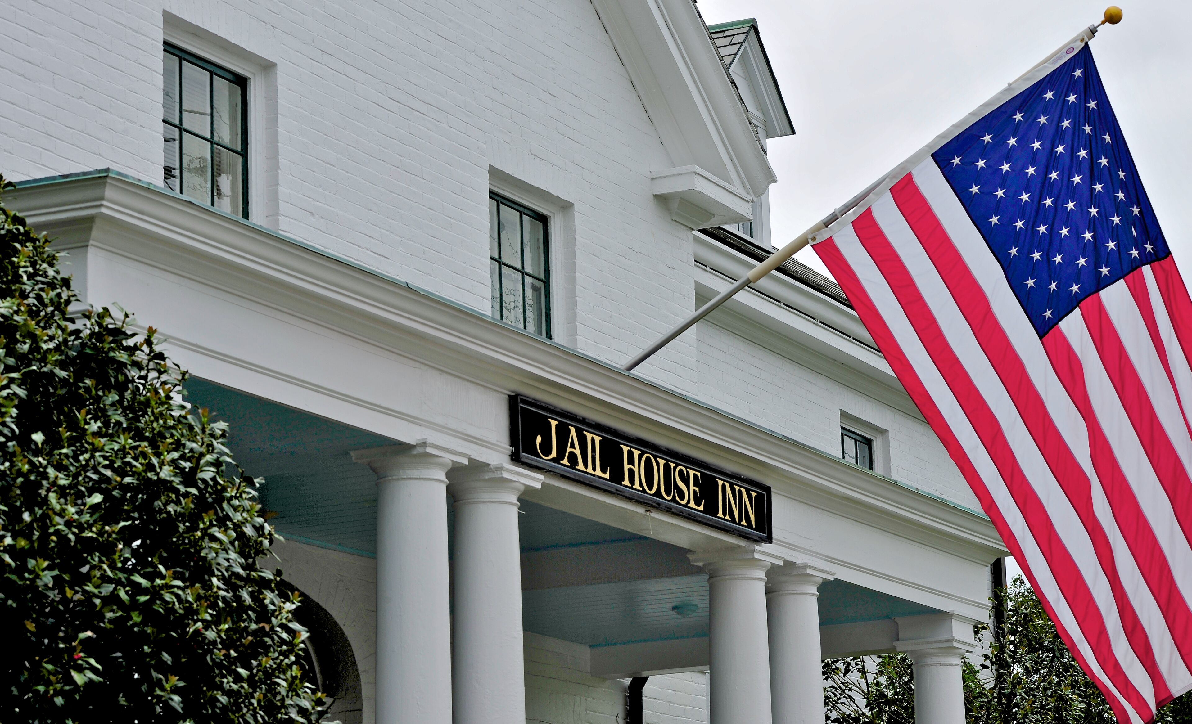 A building with a sign reading "Jail House Inn" and an American flag.