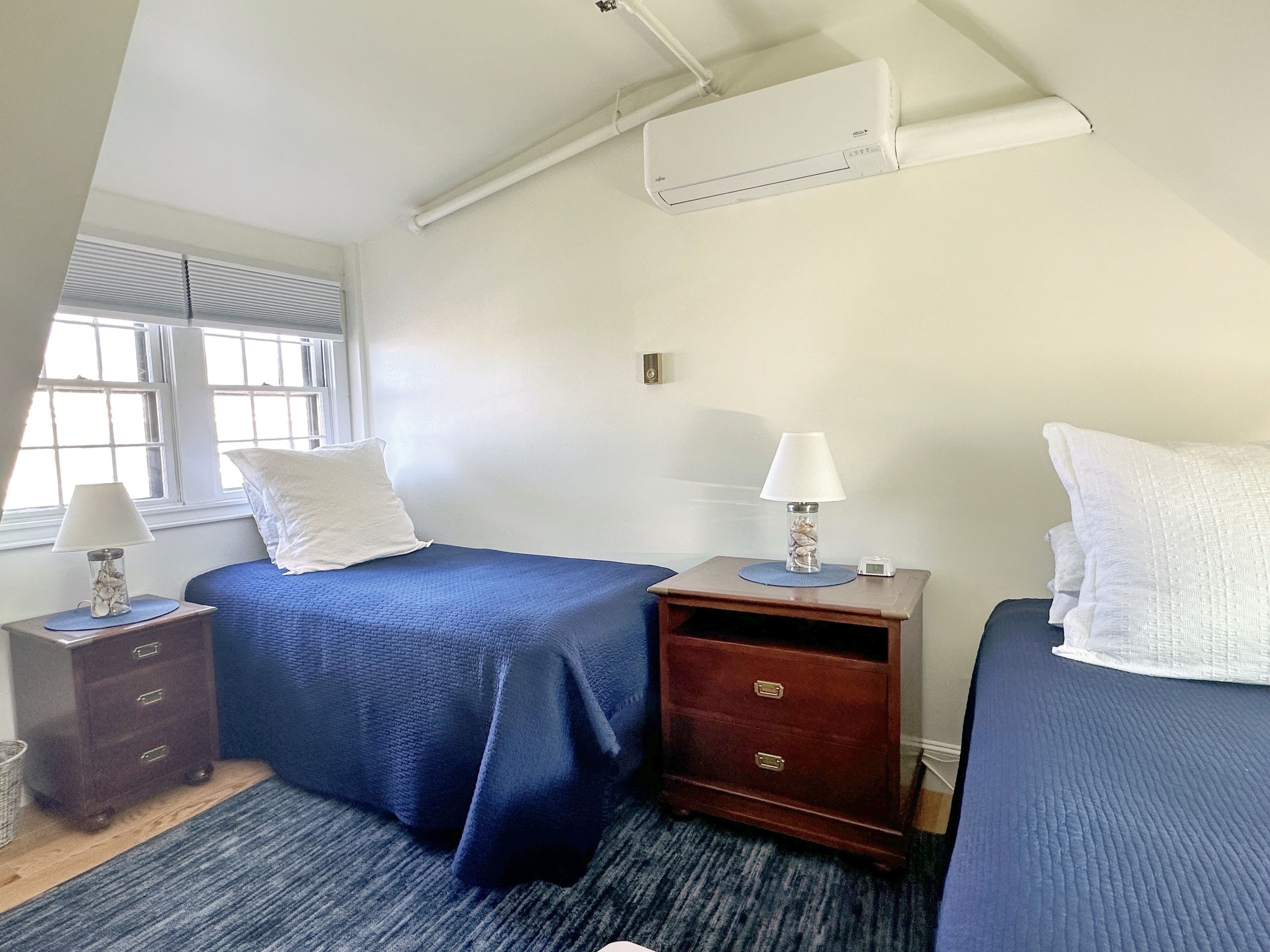 Ein Hotelzimmer mit Bett, Nachttisch, Lampe und Beistelltisch.