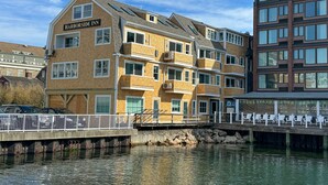 A multi-story hotel with a brick facade, balconies, and a name sign. - Harborside Inn (Newport)