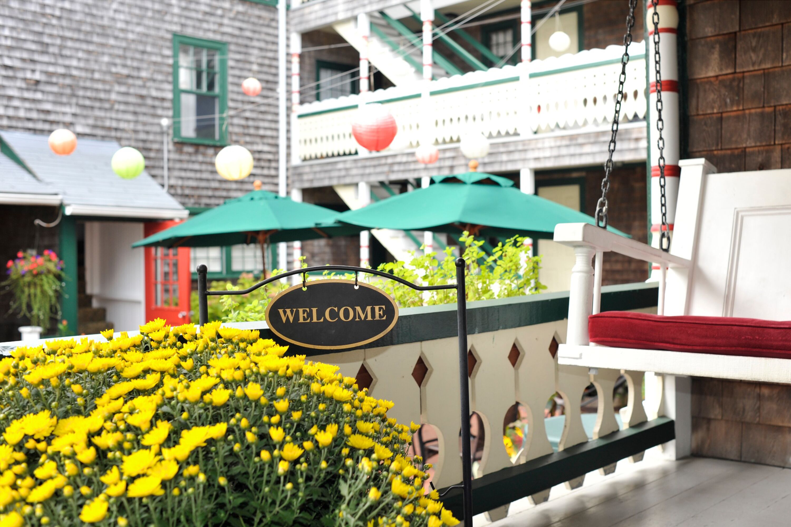 A welcome sign, a bench, and a flower bed.