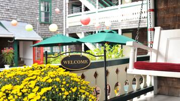 A welcome sign, a bench, and a flower bed.