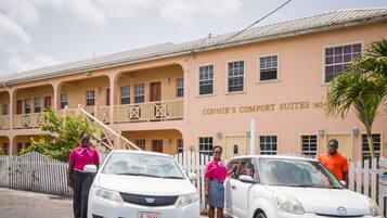 Ein Hotel mit mehreren Balkonen, einem weißen Zaun und einem Schild mit der Aufschrift "CONNIE'S COMFORT SUITES 562".