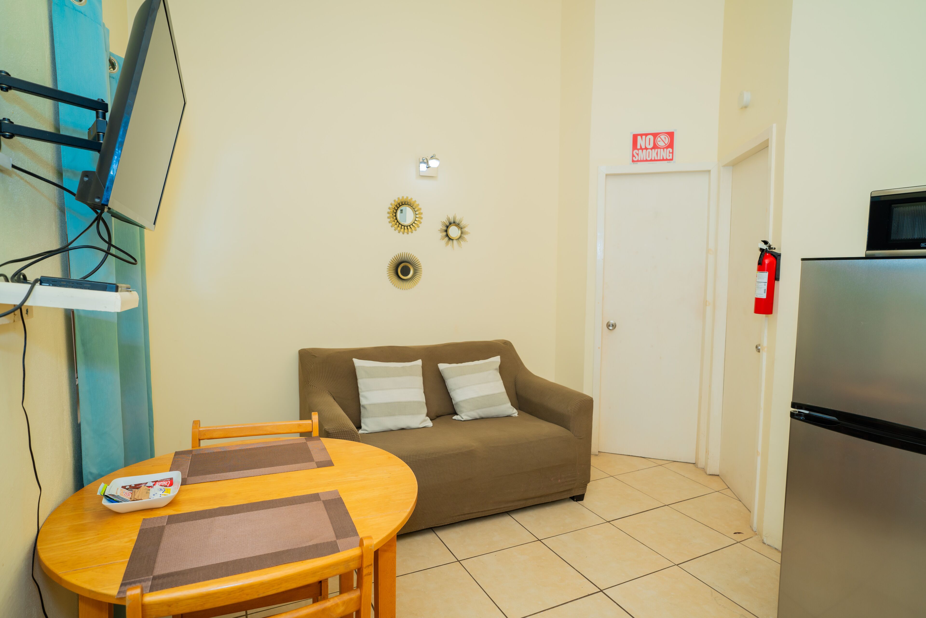 A compact living space with a sofa, a small table, and a refrigerator.
