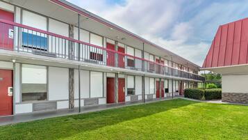 A modern building with a flat roof, multiple balconies, and a well-maintained lawn.