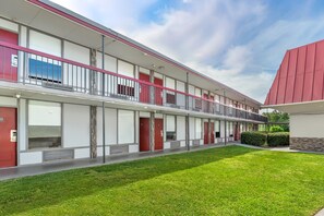 A modern building with a flat roof, multiple balconies, and a well-maintained lawn. - Red Roof Inn Richmond, VA (Richmond)