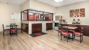 A modern restaurant with a counter, seating area, and a visible menu board. - Red Roof Inn Richmond, VA (Richmond)