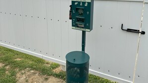 A pet waste station with a sign warning about disease transmission and a hand sanitizer dispenser. - Red Roof Inn Richmond, VA (Richmond)