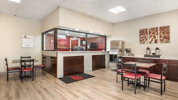 A hotel lobby with a reception desk, seating area, and artwork on the walls.