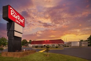 A Red Roof Inn with a large sign, a parking lot, and a building with a red roof. - Red Roof Inn Richmond, VA (Richmond)