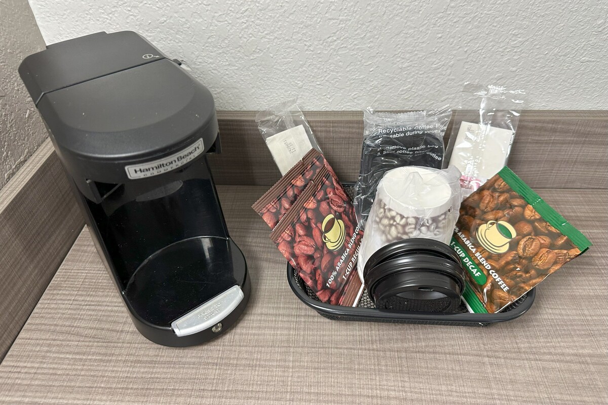 Een Hamilton Beach koffiezetapparaat met een opvangbakje, een herbruikbare koffiecup, een herbruikbare beker en een herbruikbaar koffiefilter.
