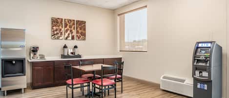 Una kitchenette equipada con refrigerador, cafetera y microondas. Cuenta con un comedor con mesa y sillas.