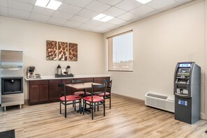 A kitchenette with a refrigerator, coffee maker, and a microwave. There is a dining area with a table and chairs. - Red Roof Inn Richmond, VA (Richmond)