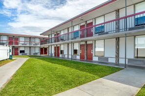 A modern multi-story building with a flat roof, large windows, and a well-maintained lawn. - Red Roof Inn Richmond, VA (Richmond)