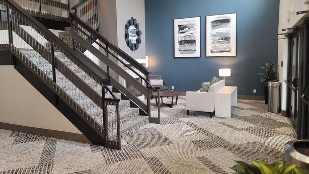 A modern lobby with a staircase, a reception desk, and two abstract paintings on the wall. - Isle Casino Hotel Lula Hotel & Casino - A Caesars Rewards Destination (Lula)