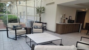 A modern hotel lobby with a seating area, a reception desk, and large windows. - Isle Casino Hotel Lula Hotel & Casino - A Caesars Rewards Destination (Lula)