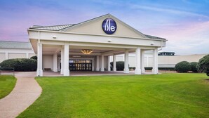 A hotel entrance with a covered area, a sign reading "Casino Entrance," and a well-maintained lawn. - Isle Casino Hotel Lula Hotel & Casino - A Caesars Rewards Destination (Lula)