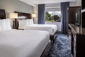 A hotel room with two beds, a TV, and a view of a park. - Isle Casino Hotel Lula Hotel & Casino - A Caesars Rewards Destination (Lula)