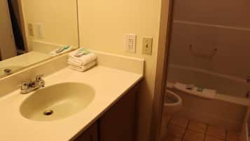 A bathroom with a sink, mirror, and toilet.