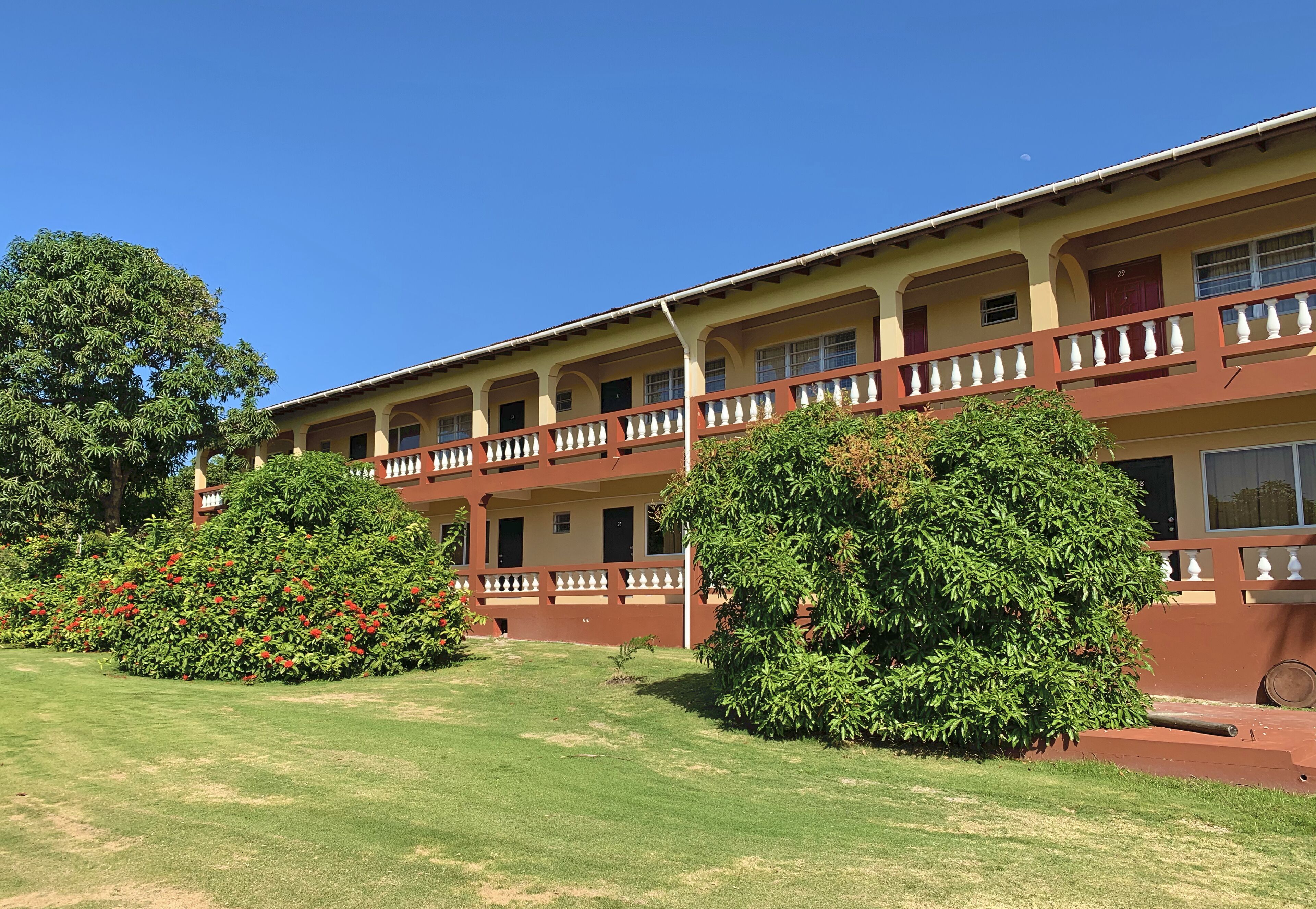 A two-story building with a flat roof and a balcony on each floor.