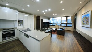 Una cocina moderna con armarios blancos, horno empotrado y una isla grande con lavamanos.