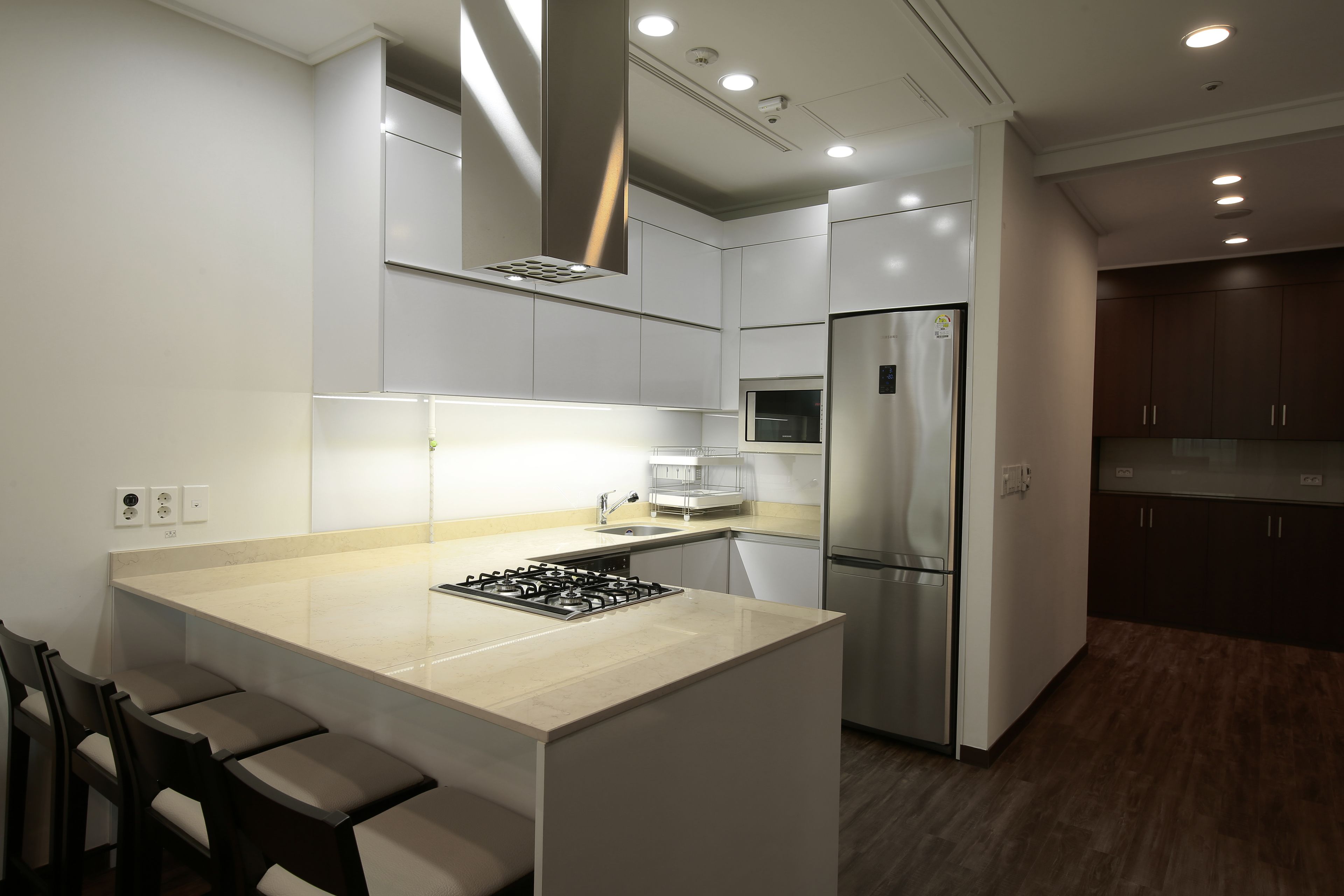 A modern kitchen with a central island, stainless steel appliances, and a built-in microwave.