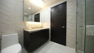 A modern bathroom with a toilet, sink, and mirror.