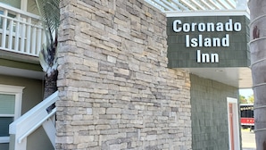 Mur de pedra amb un senyal per a Coronado Island Inn.