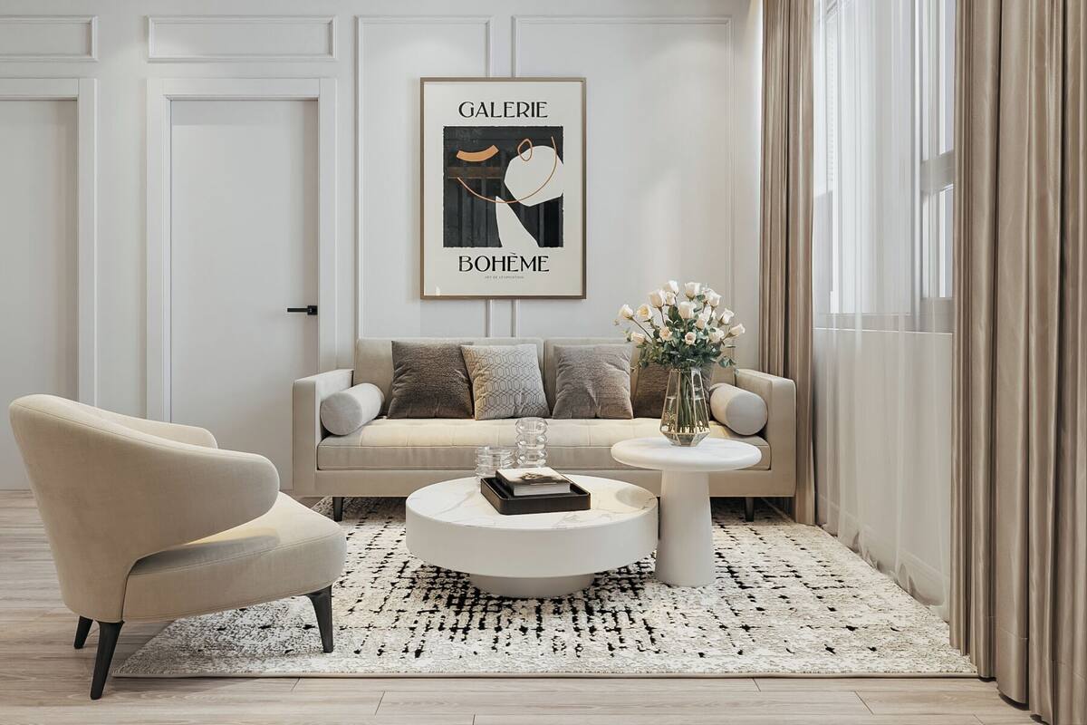 A modern living room with a sofa, armchair, coffee table, and a framed artwork on the wall.