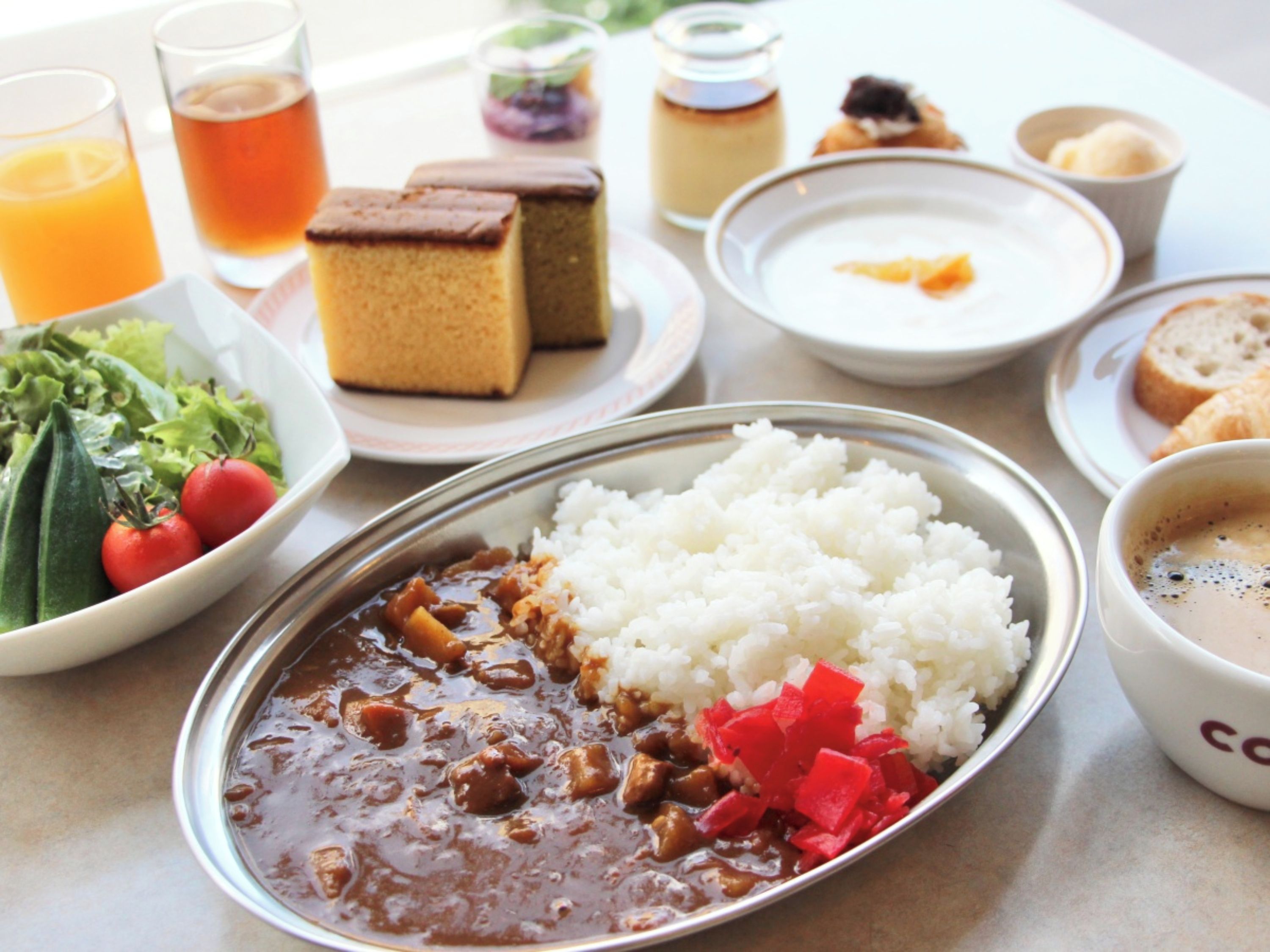 Un repas composé de riz, de haricots et de légumes, accompagné de boissons et de desserts.