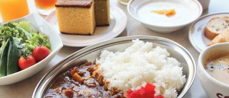 Un repas composé de riz, de haricots et de légumes, accompagné de boissons et de desserts.