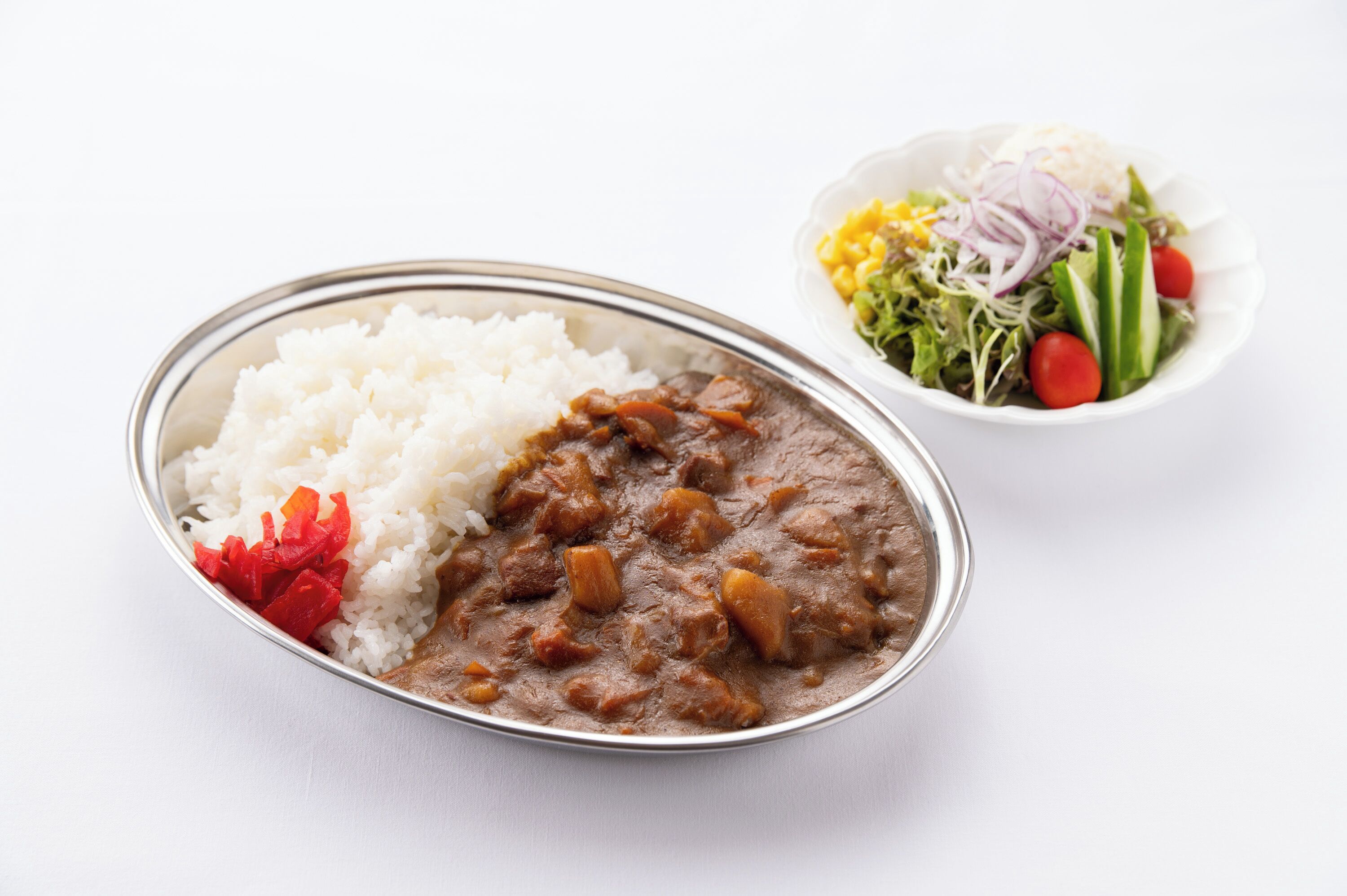 A meal consisting of rice, a meat-based dish, and a salad.
