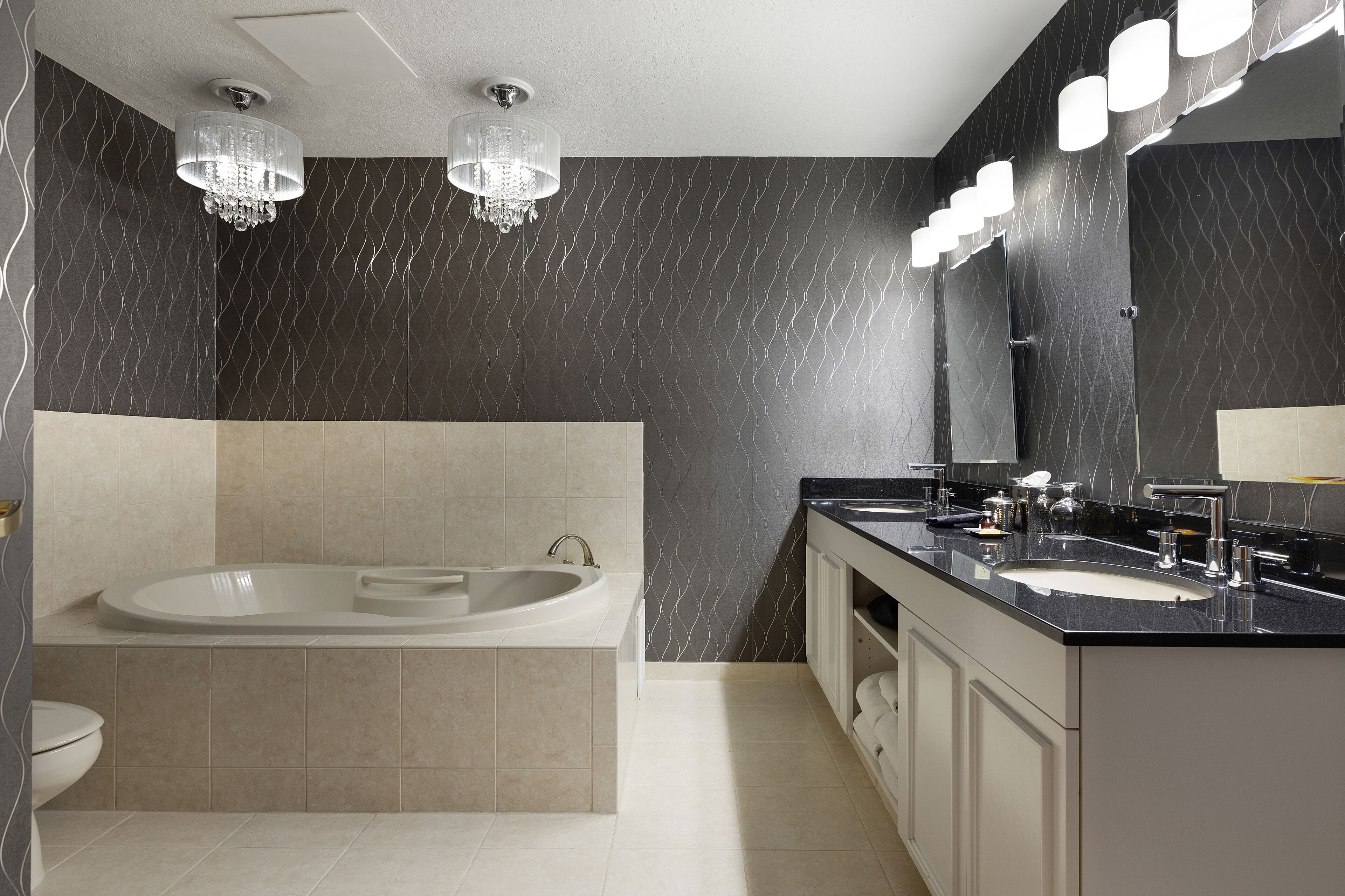 Un baño moderno con una bañera independiente, un tocador doble y un espejo grande.